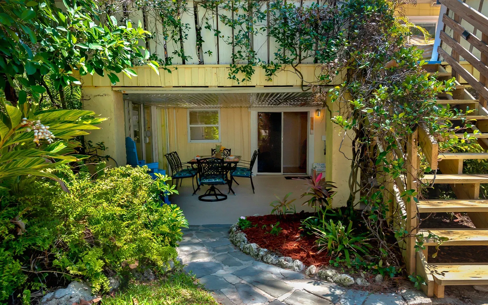 There is a patio with a table and chairs in the backyard of a house.