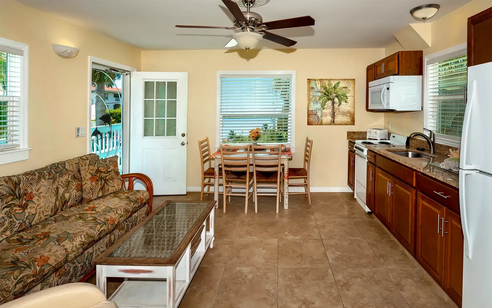 A living room with a couch a table and a ceiling fan