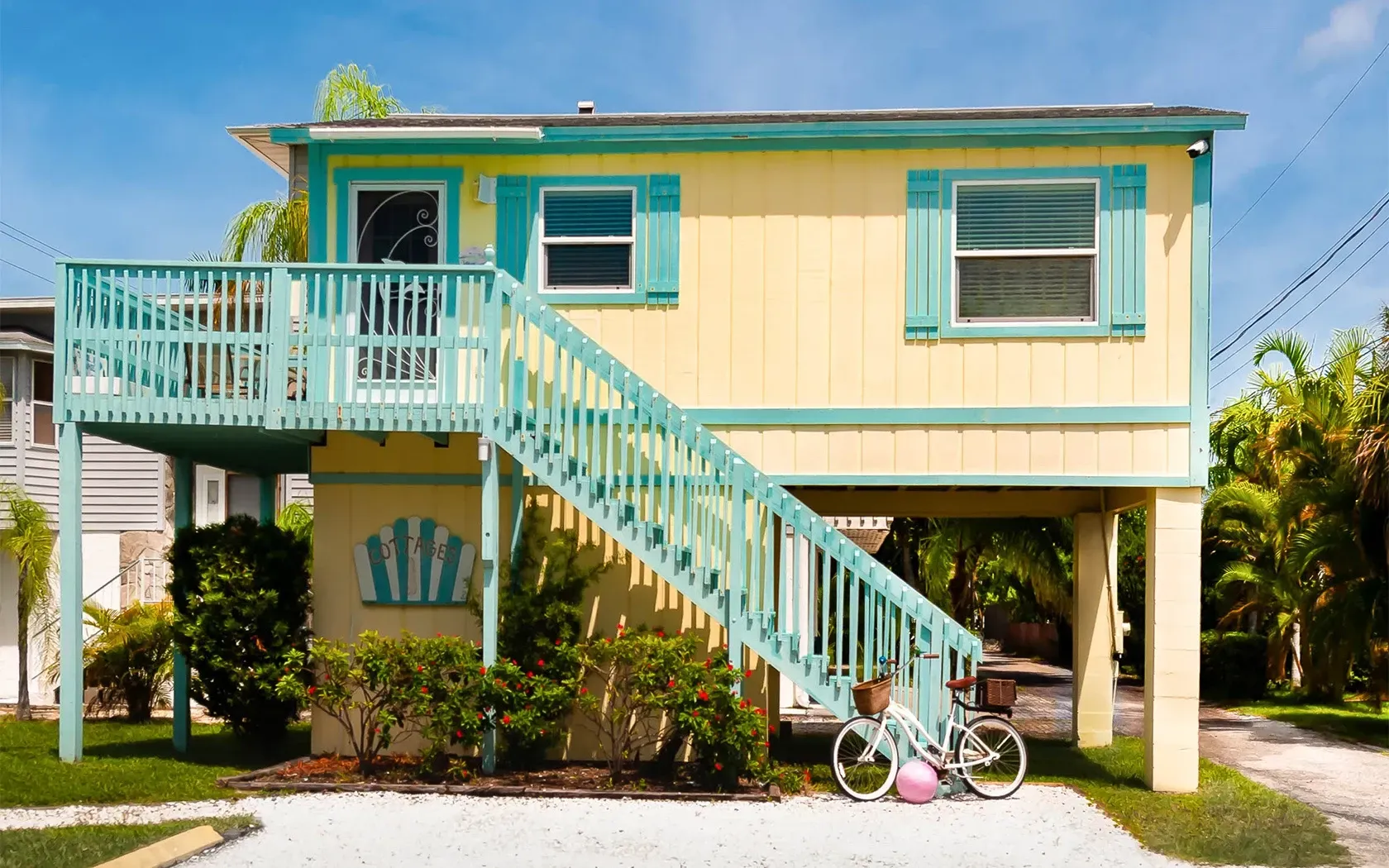 A yellow and blue house with stairs leading up to the second floor