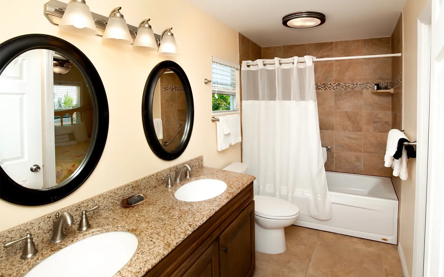 A bathroom with two sinks a toilet and a bathtub