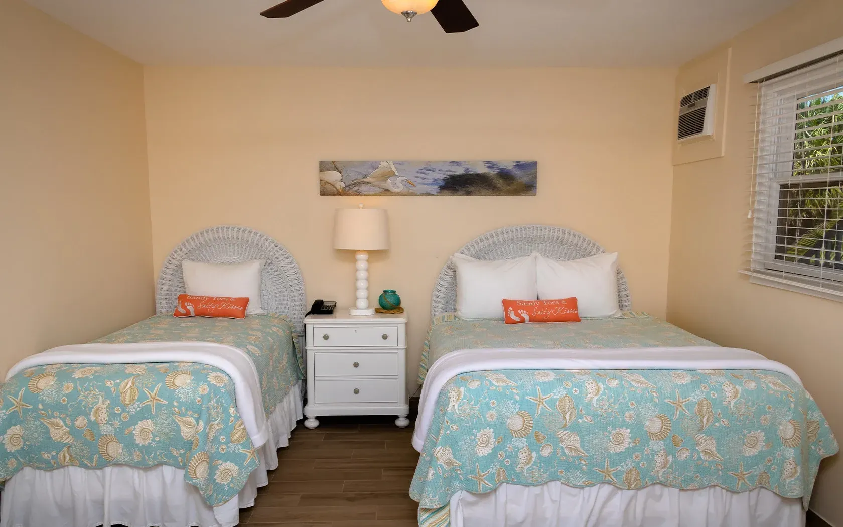 A bedroom with two beds and a ceiling fan.