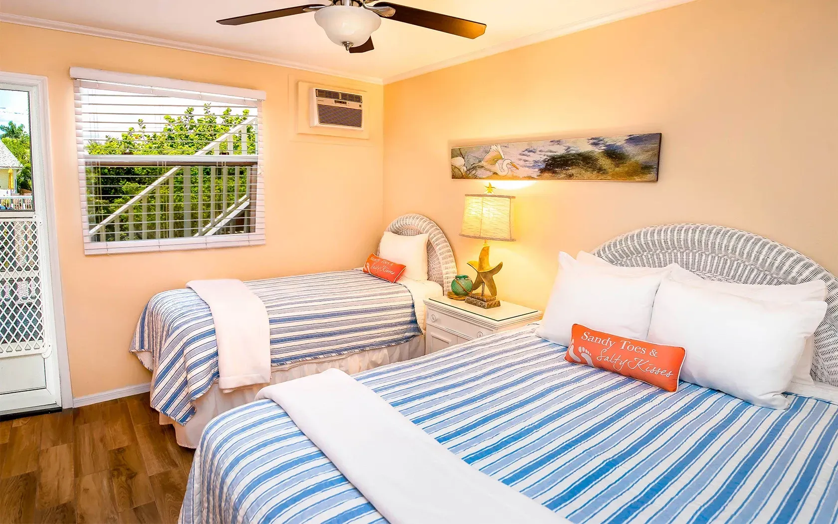 A bedroom with two beds and a ceiling fan.