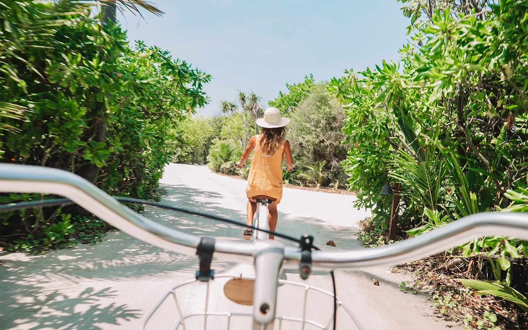 A woman is riding a bike down a path.