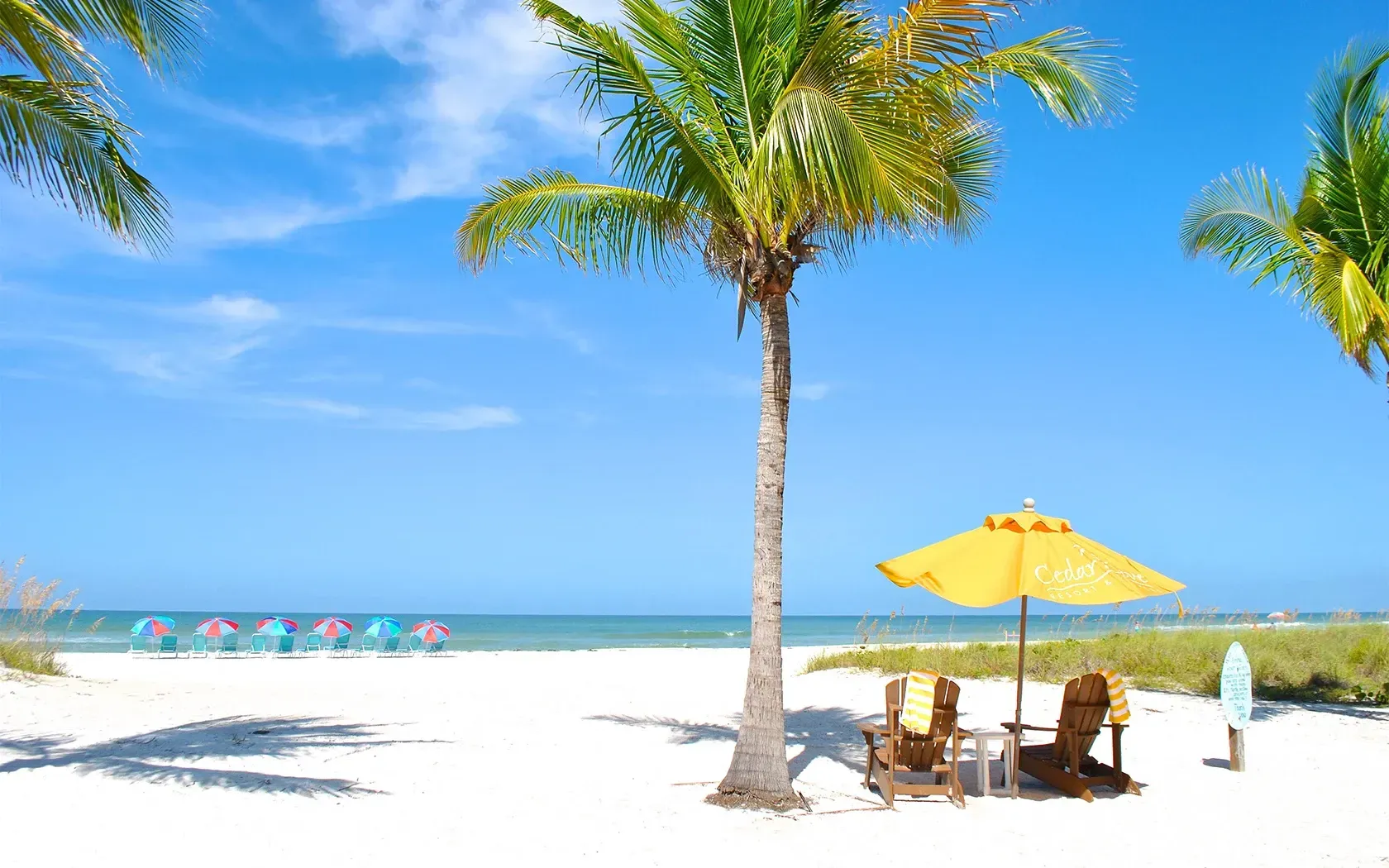 There is a table and chairs under an umbrella on the beach.