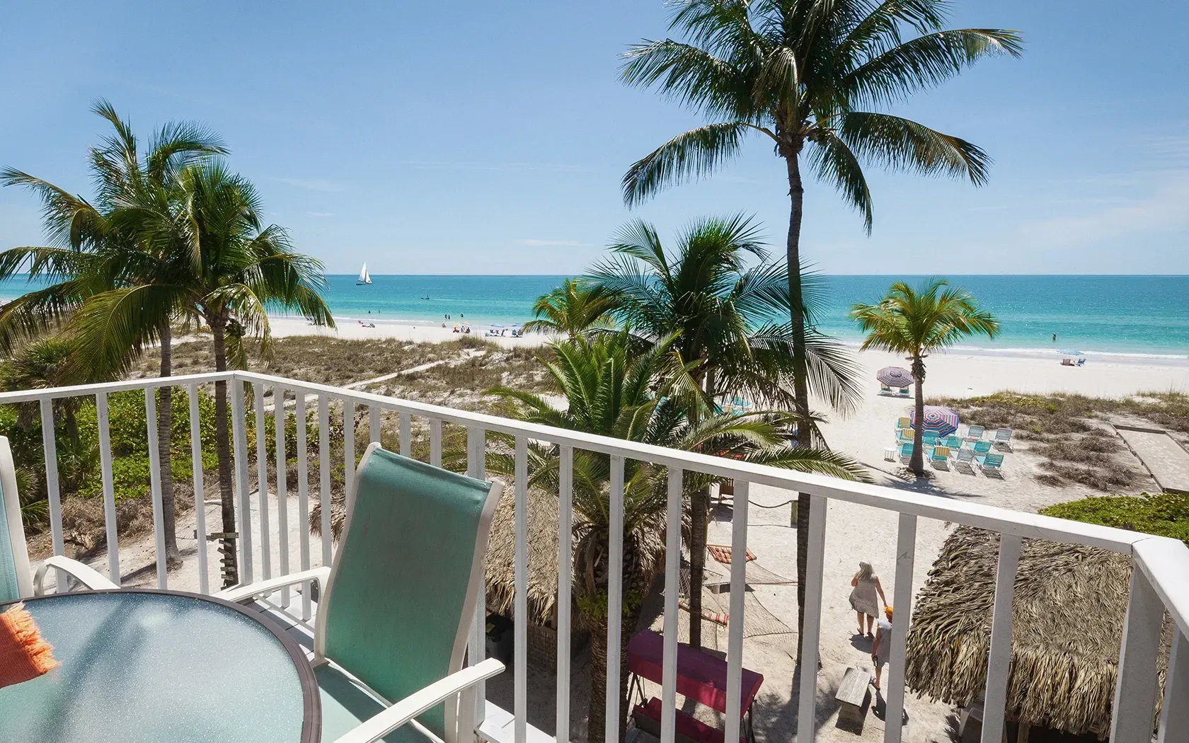 A balcony with a view of the ocean and palm trees