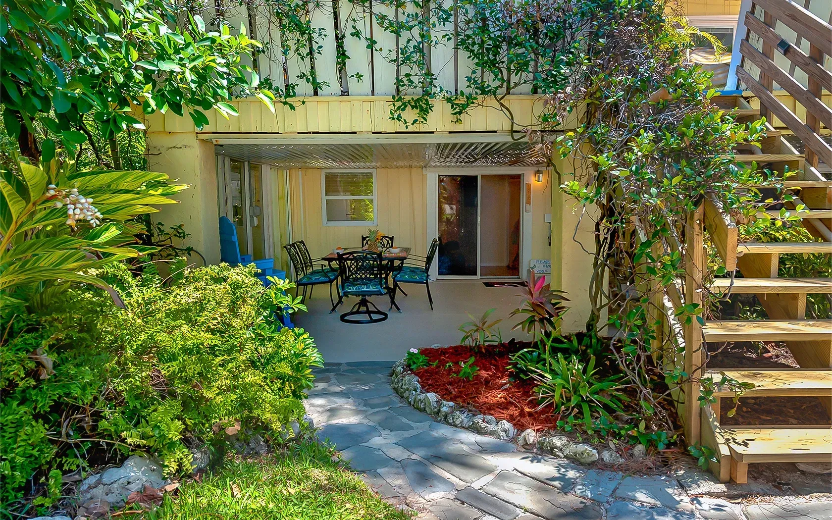 There is a patio with a table and chairs and stairs leading up to it.