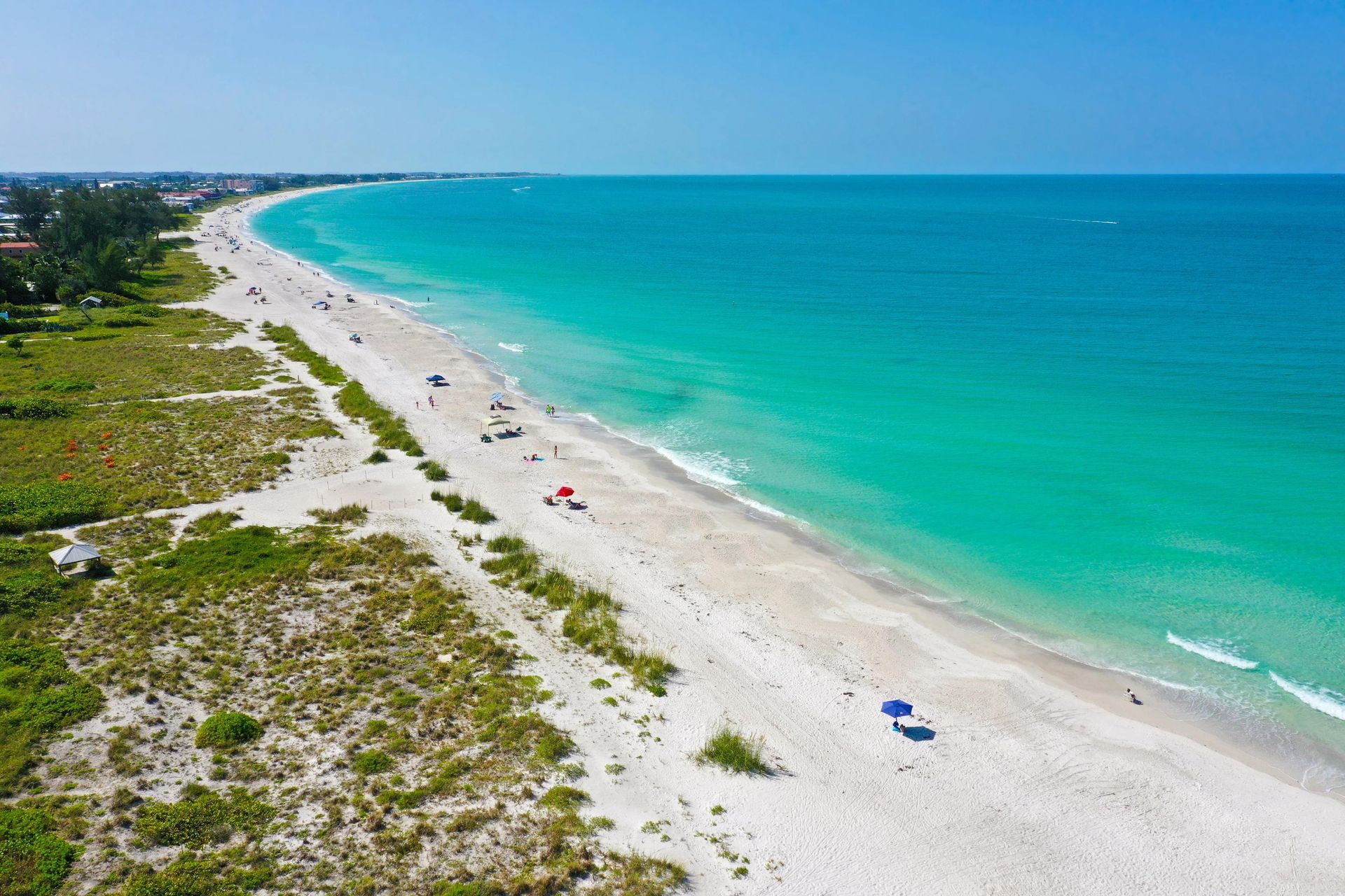 An aerial view of a beach with people and umbrellas.
