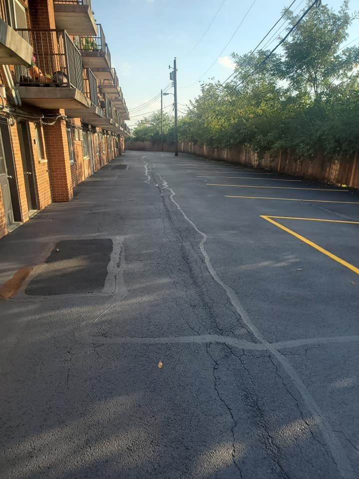 An empty parking lot in front of a row of apartment buildings
