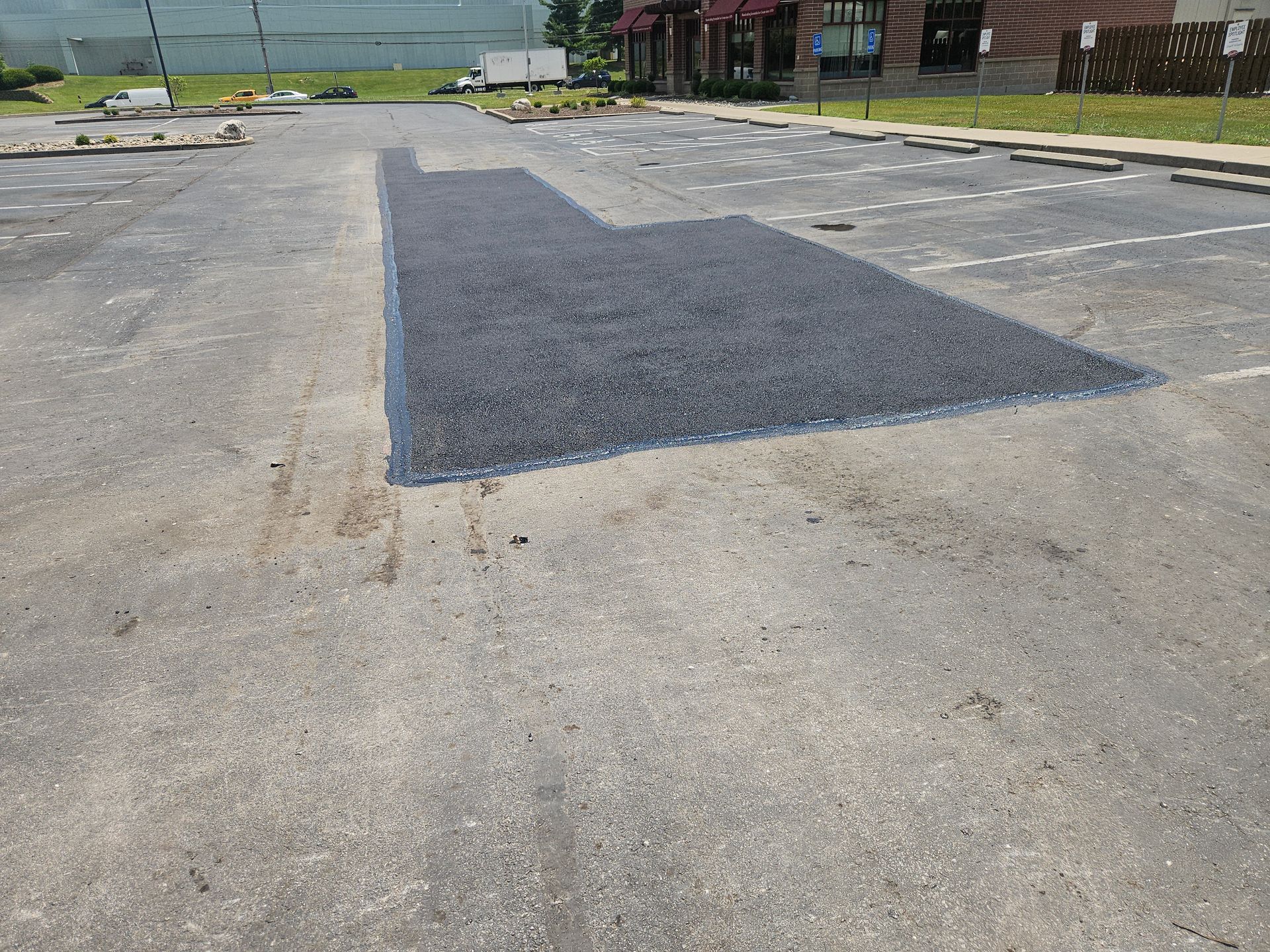 An empty parking lot in front of a row of apartment buildings