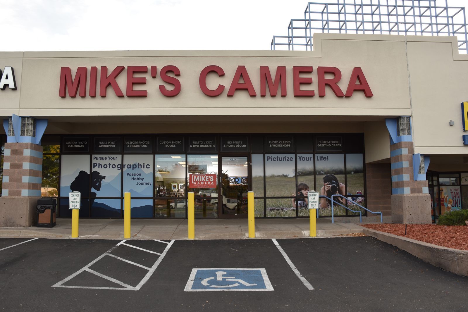 Mike's Camera store with a red location marker on a sunny day.