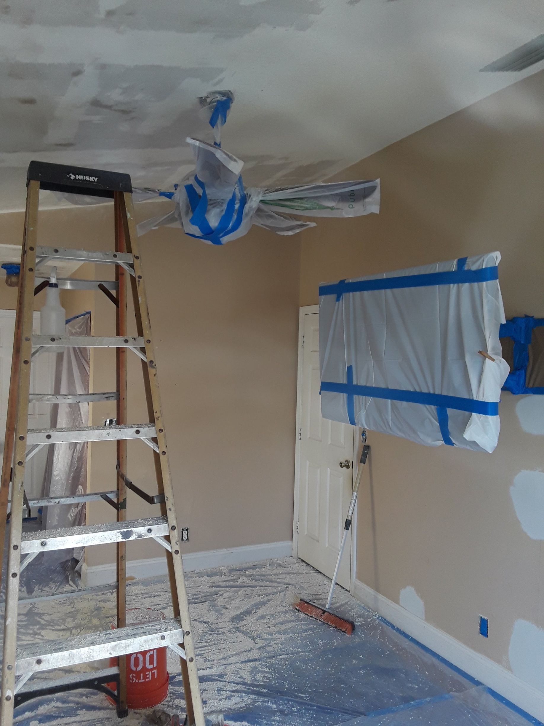 A room with a ladder and a ceiling fan in it