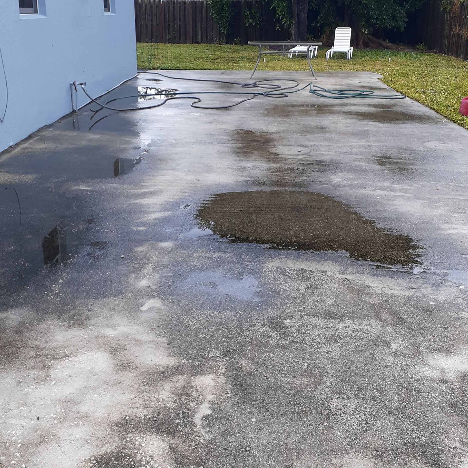 A concrete driveway with a puddle in the middle of it