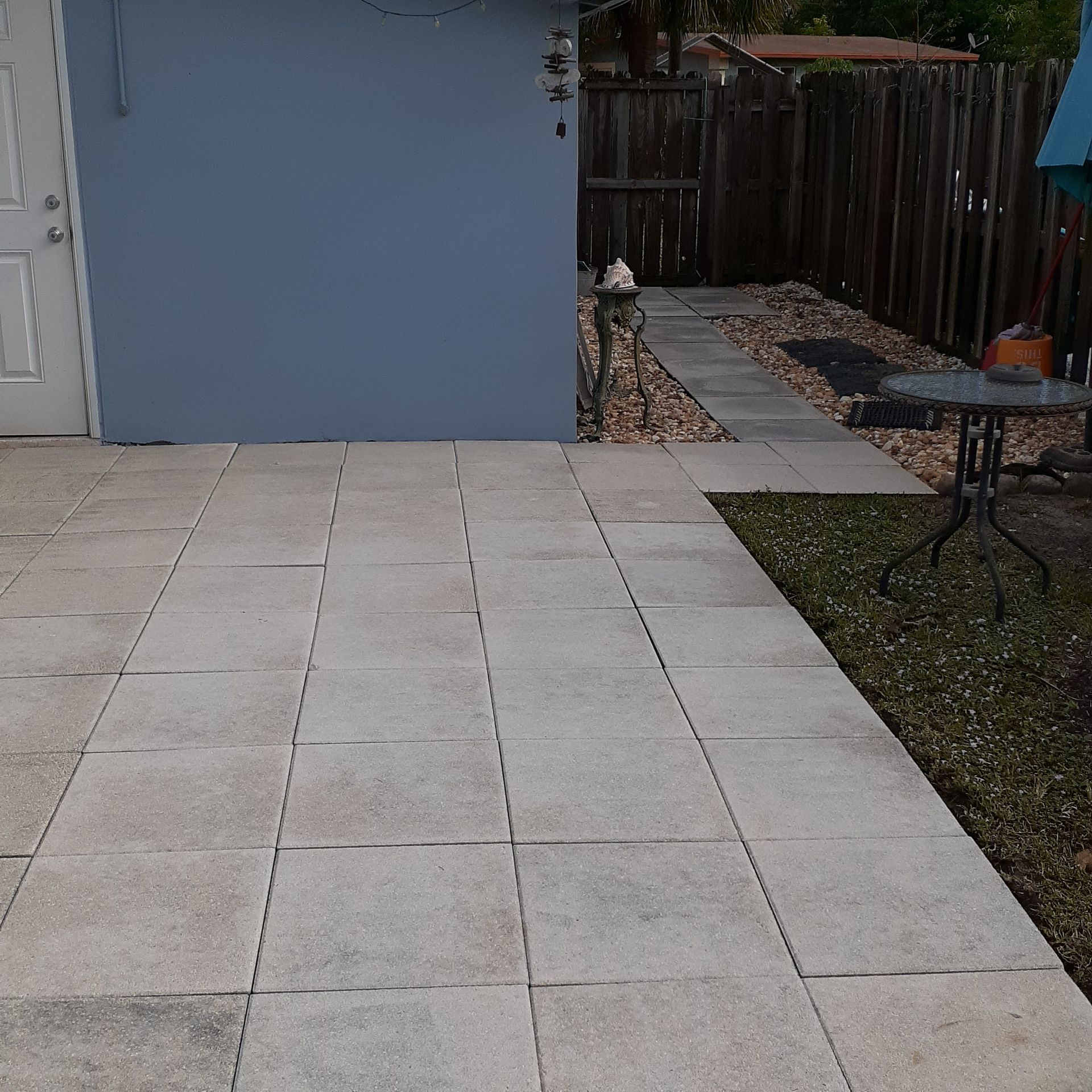 A patio with a table and a fence in the background