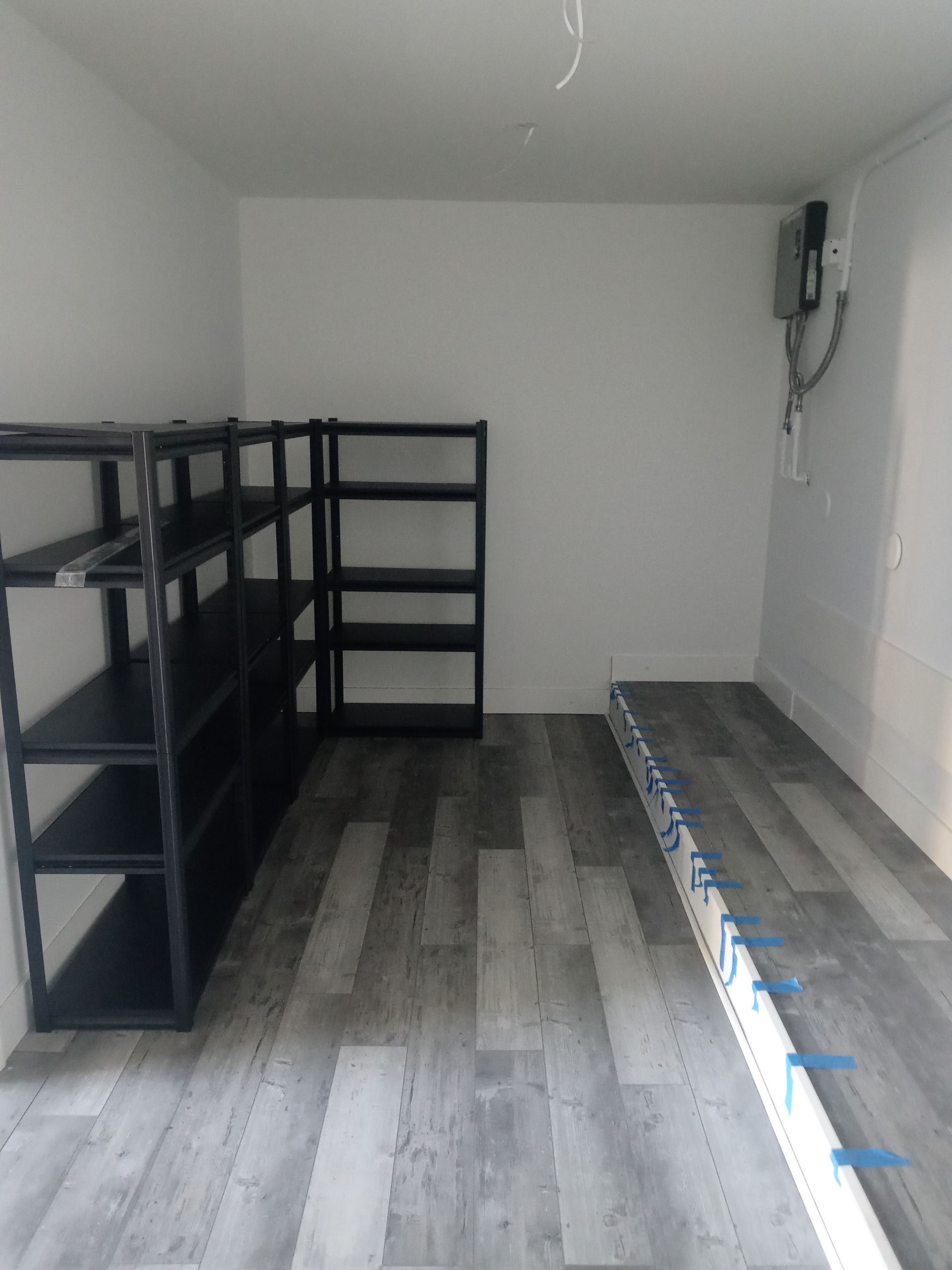 A room with a wooden floor and shelves in it