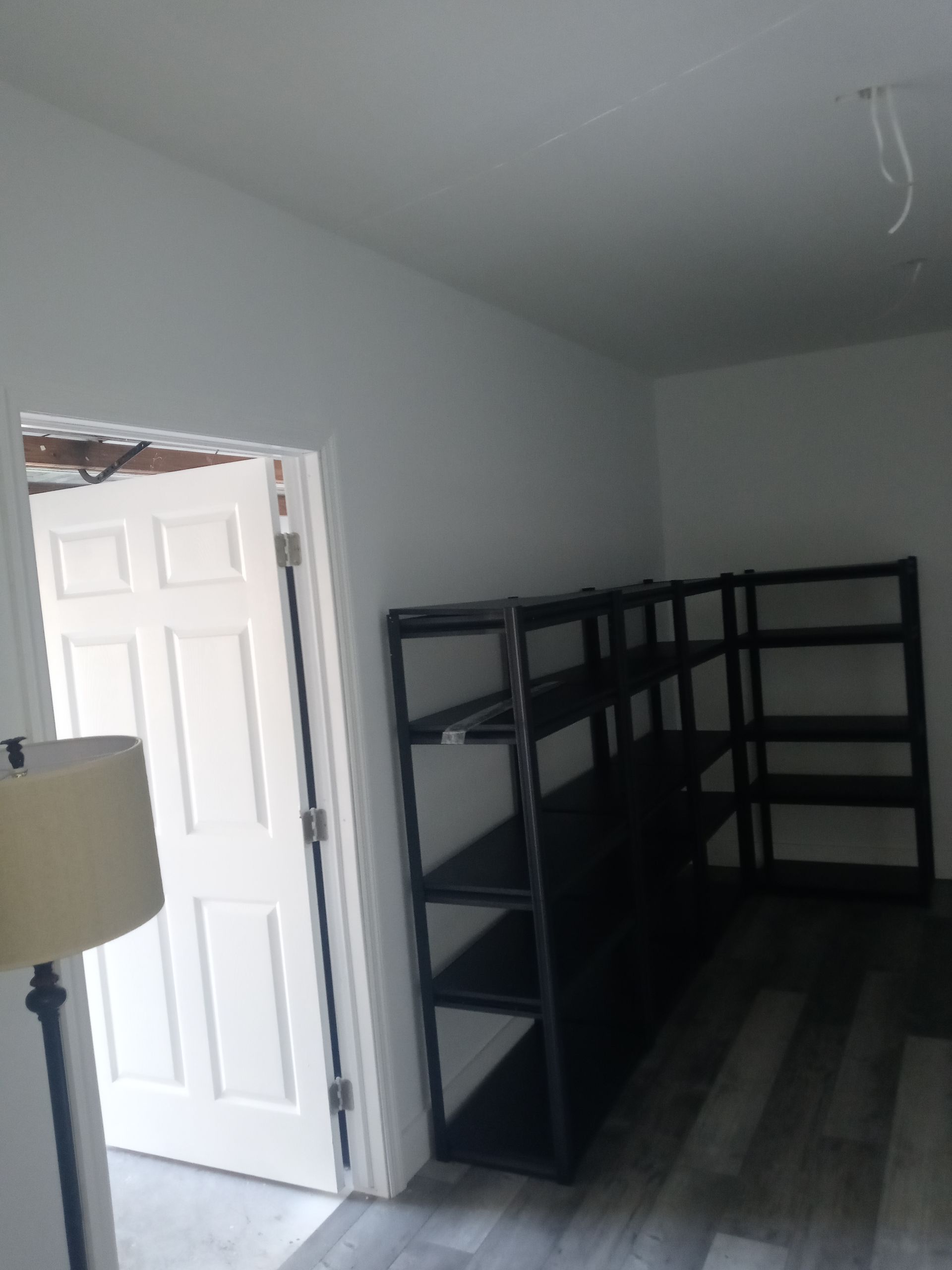 A room with a lamp and shelves in it