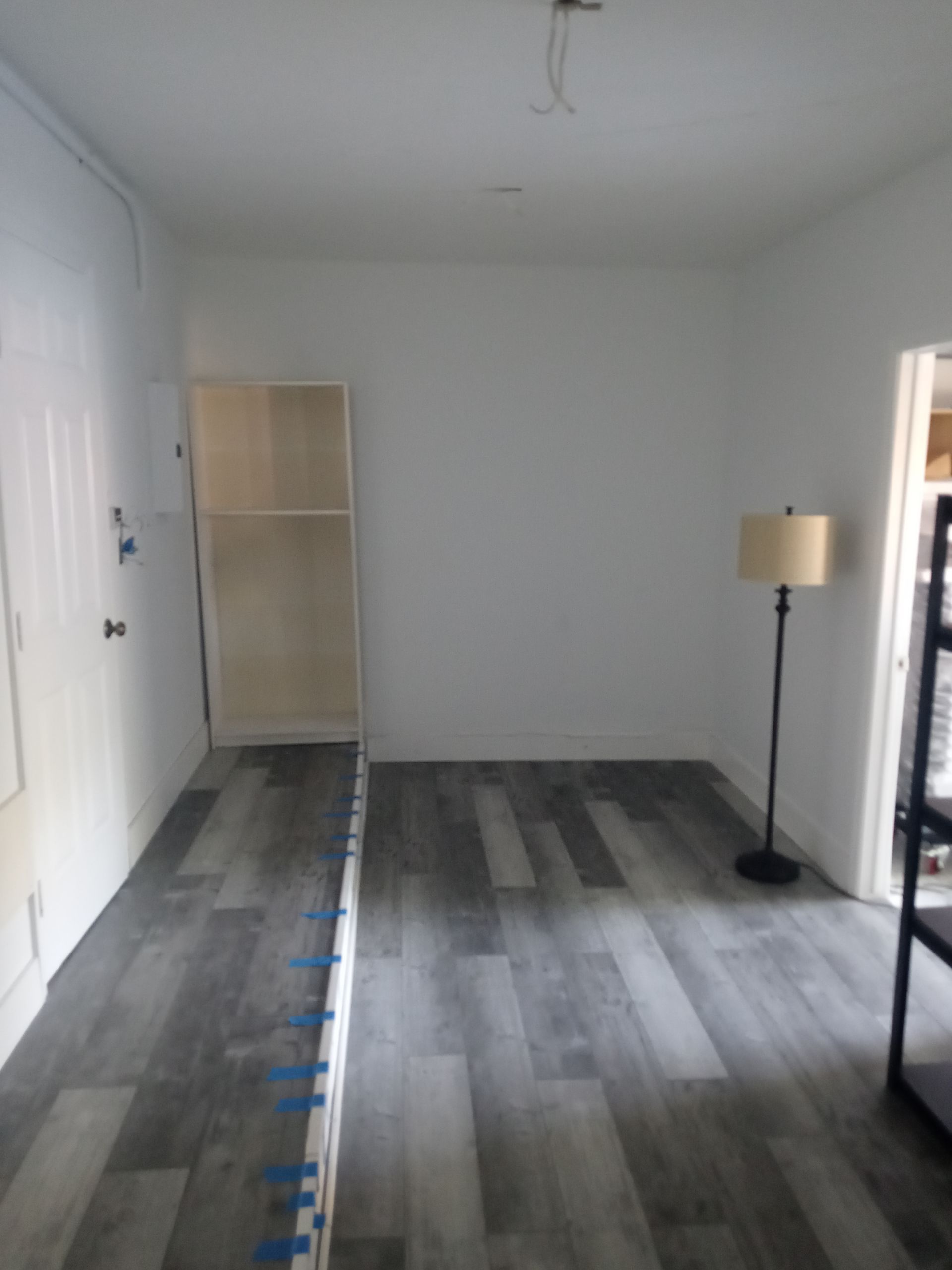 An empty room with a lamp on the floor