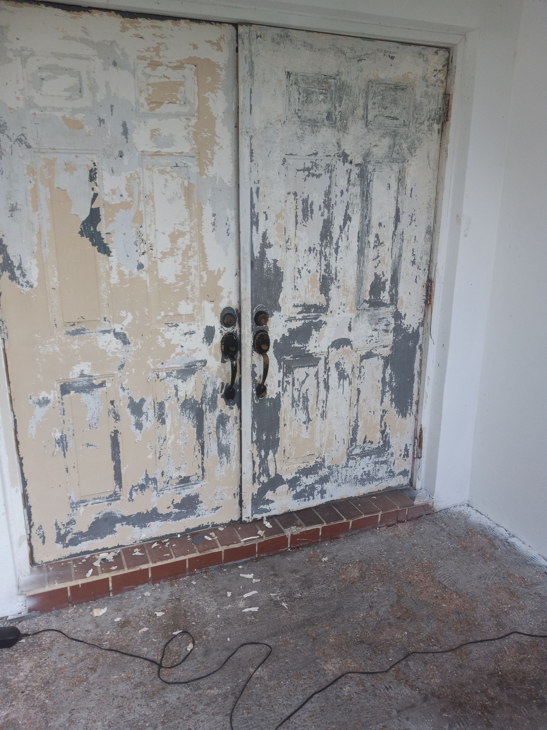 A pair of doors that are peeling paint in a room