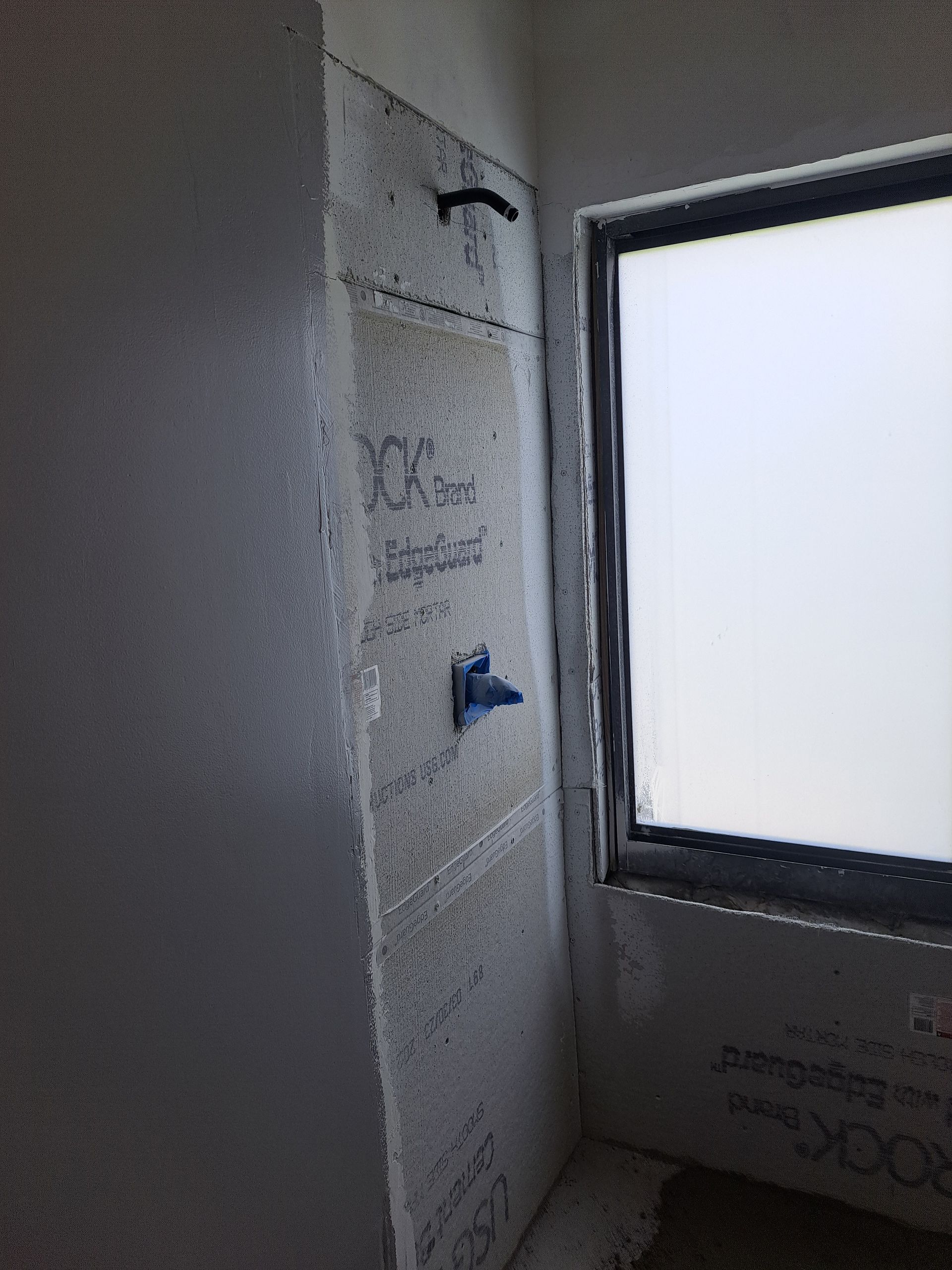 A bathroom with a shower and a window.