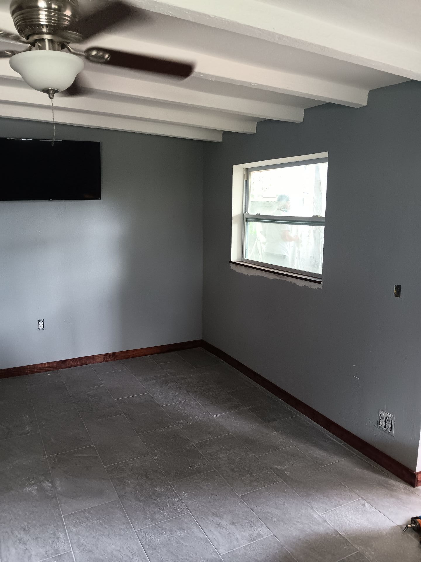 A room with a ceiling fan and a window