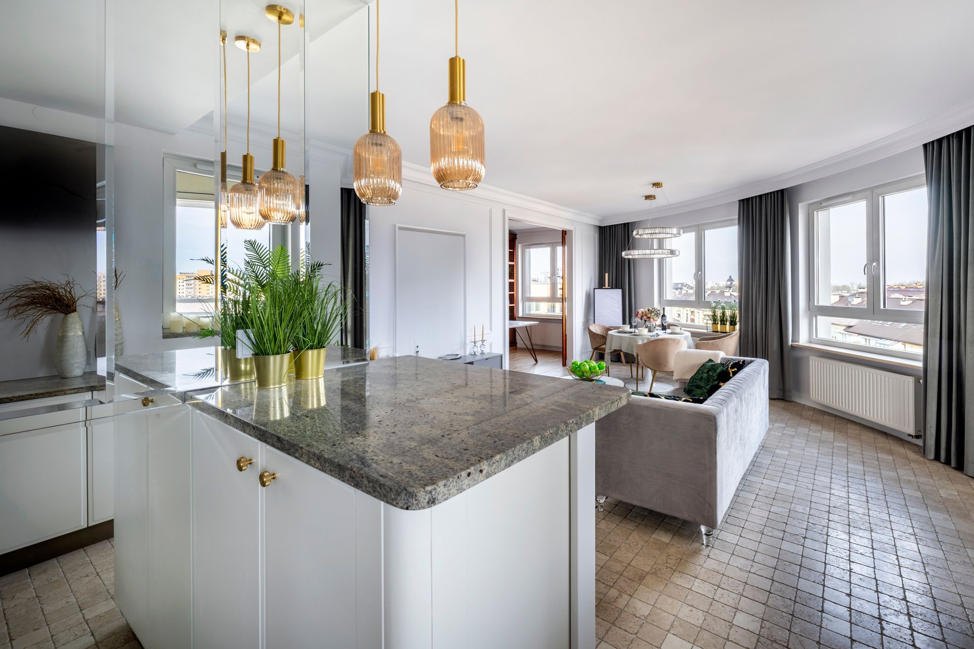 A living room with a couch and a kitchen with a granite counter top.