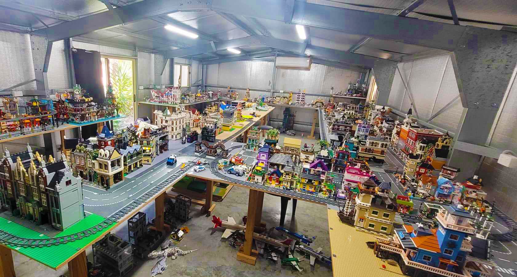 Large room filled with a massive Lego city, with buildings, roads, and figures.