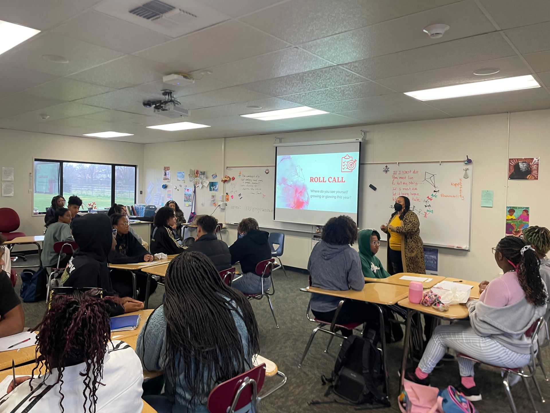 A person is giving a presentation to a group of students in a classroom.