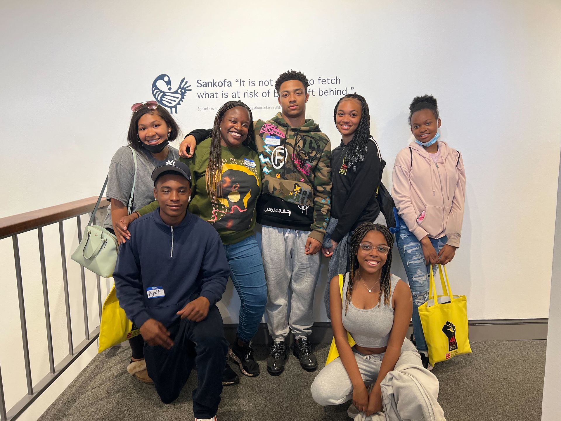 A group of young people are posing for a picture in a hallway.