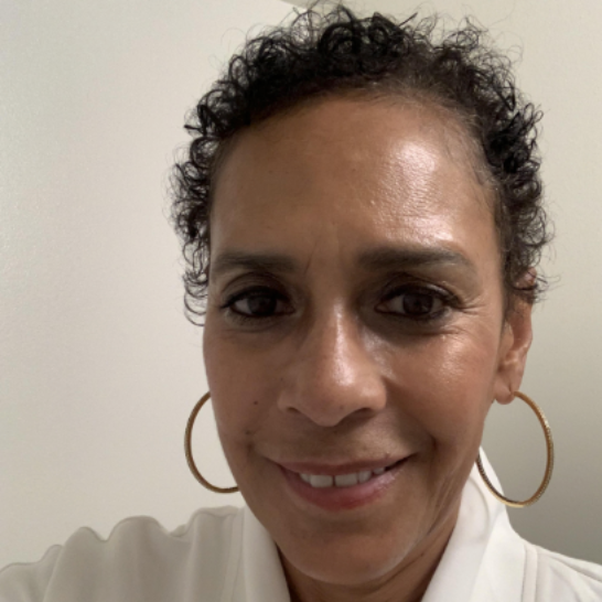 A woman with short hair wearing a white top