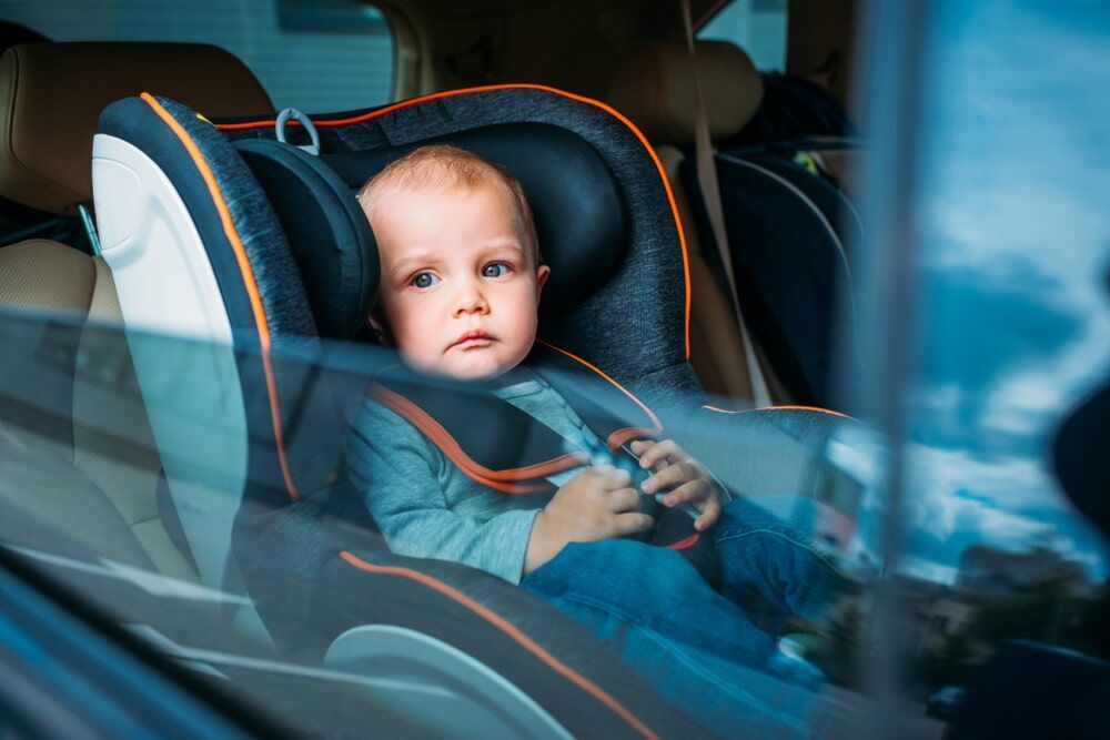 A Baby is Sitting in a car Seat in the Back Seat of a Car — Mechanical Servicesin Maroochydore, QLD