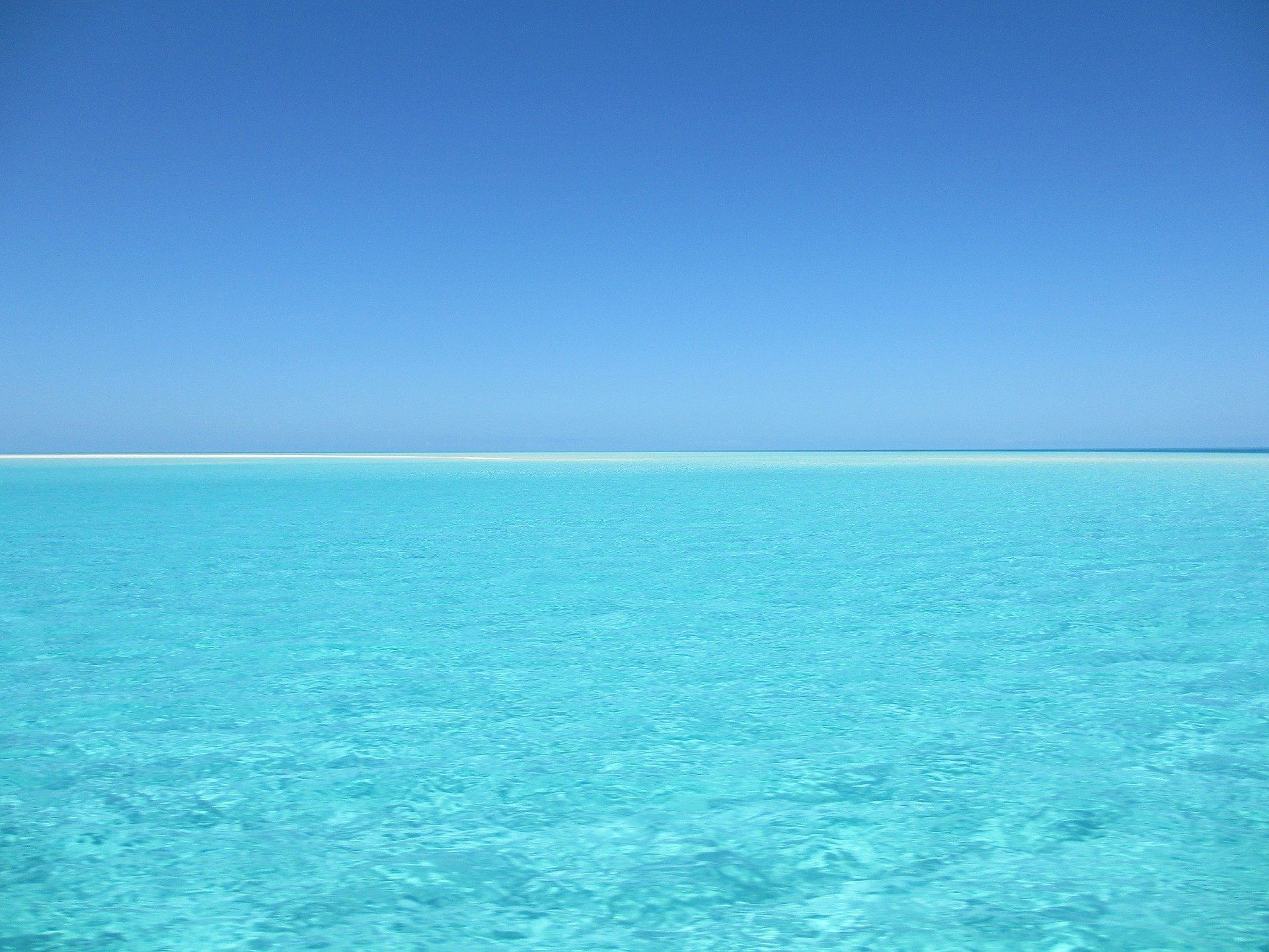 A large body of water with a blue sky in the background.