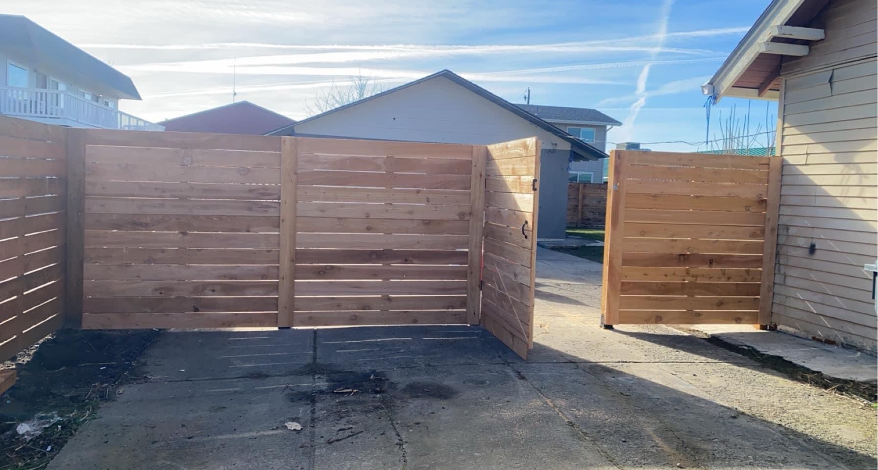A wooden deck with stairs leading up to it and trees in the background.