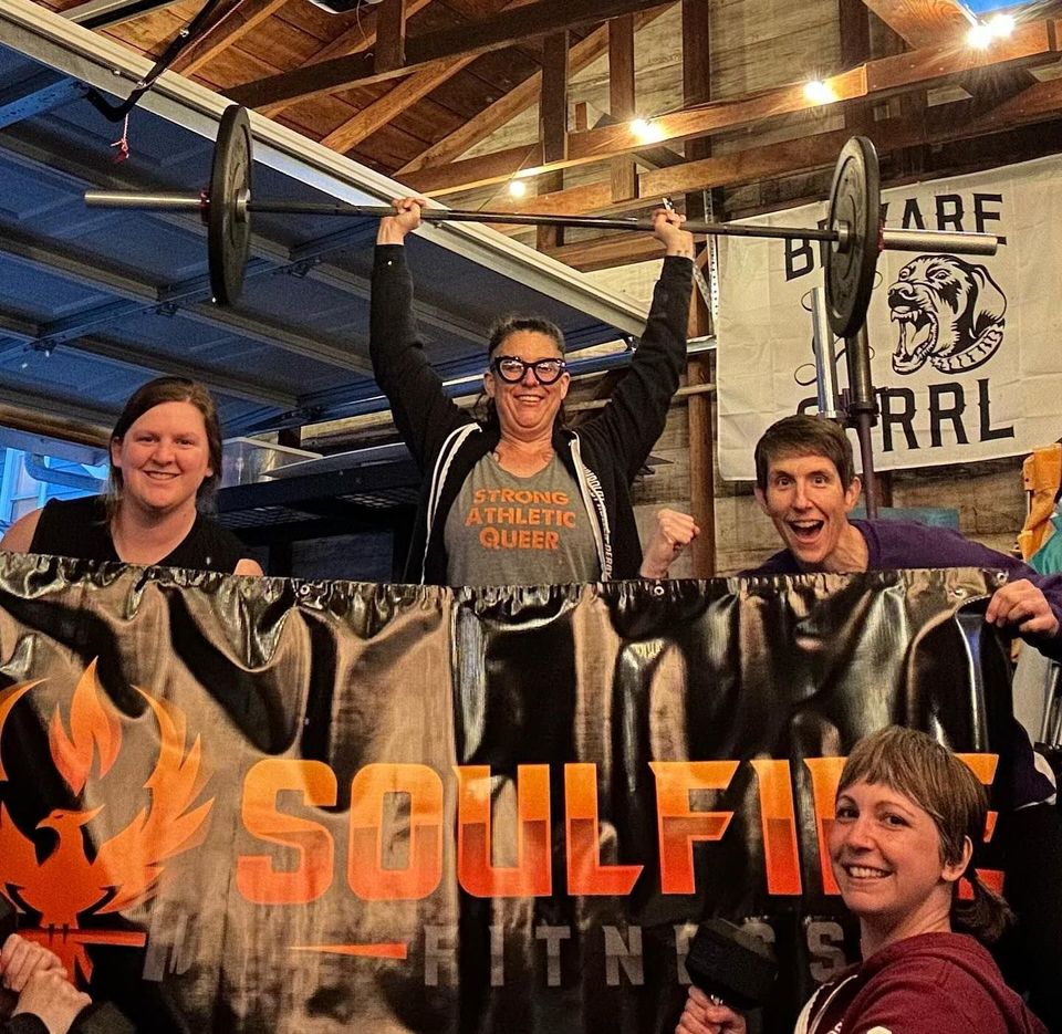 A group of people are holding a banner that says soulfire fitness.