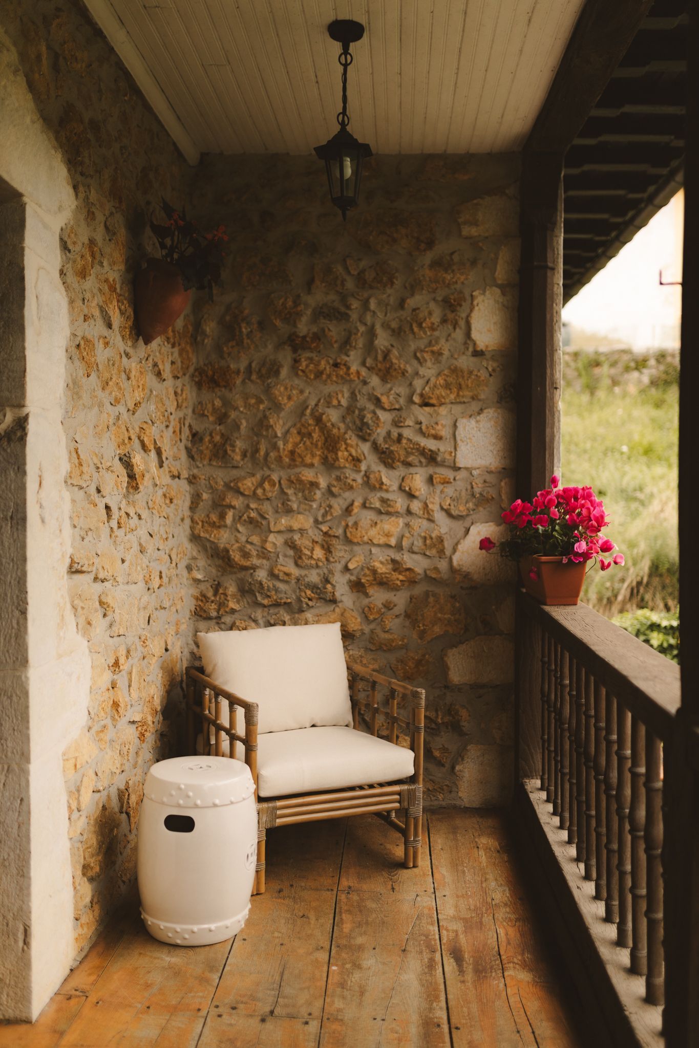 There is a chair and a stool on the balcony.