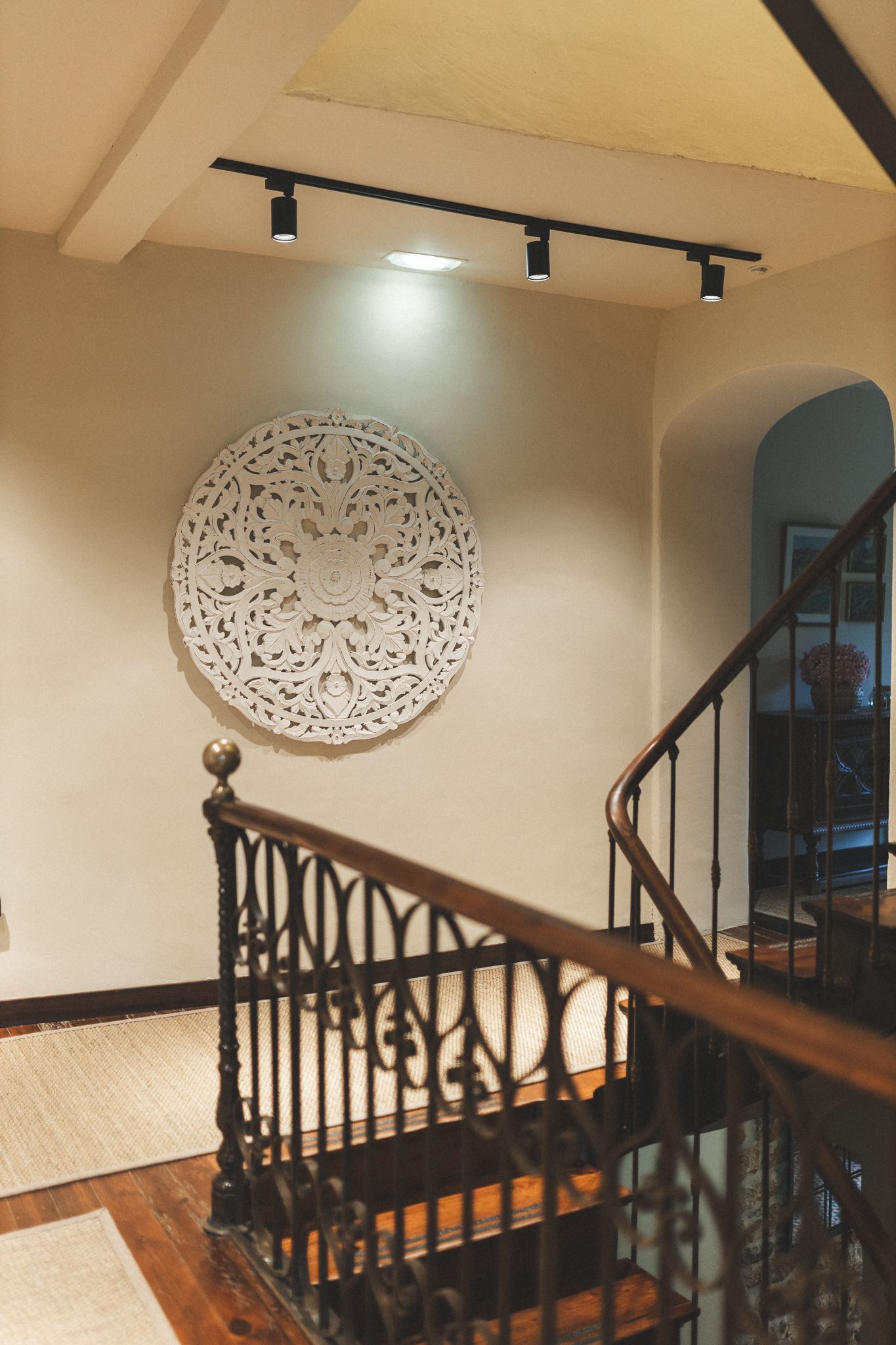A staircase with a circular decoration on the wall above it