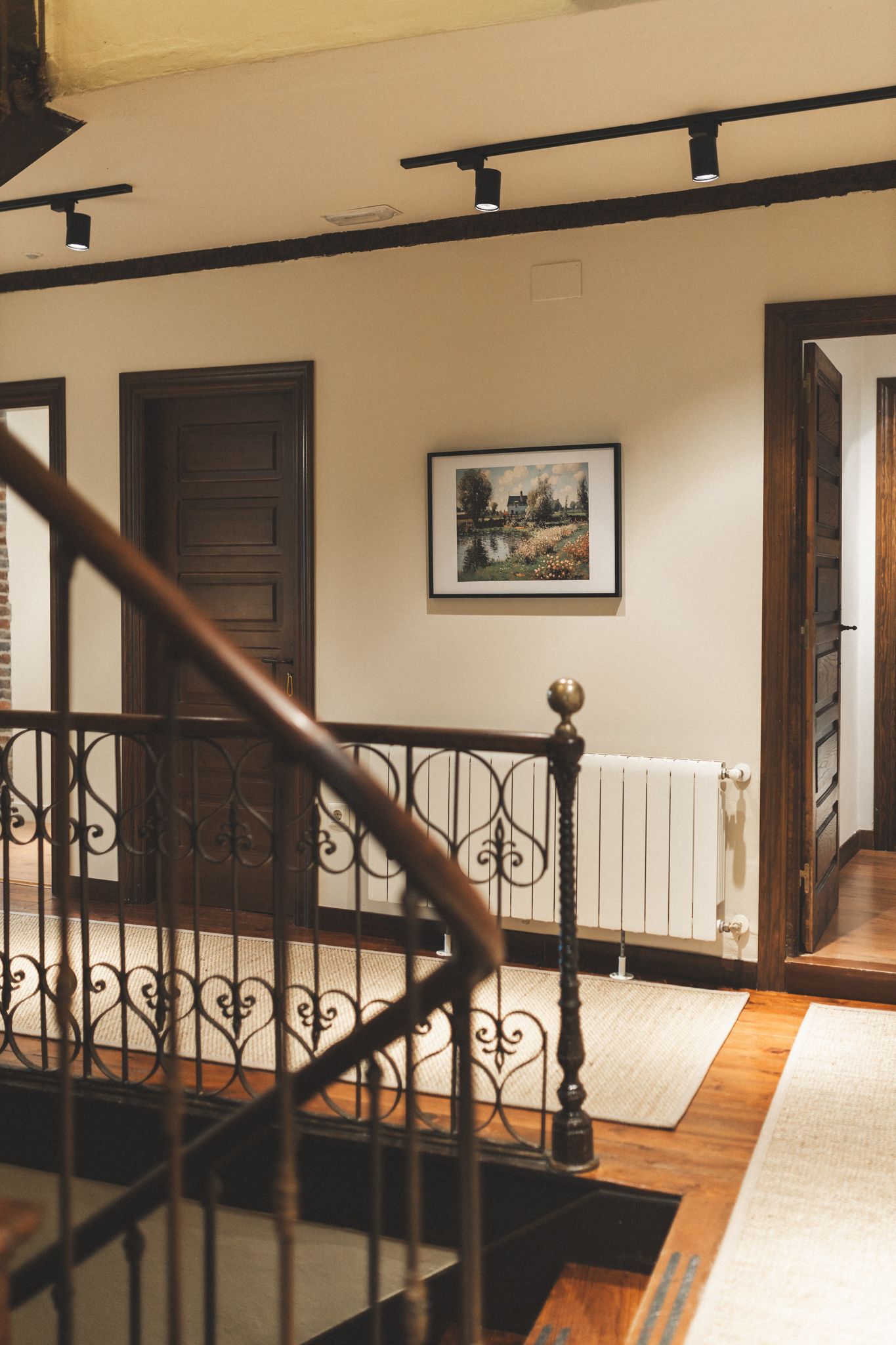 A hallway with stairs and a picture on the wall
