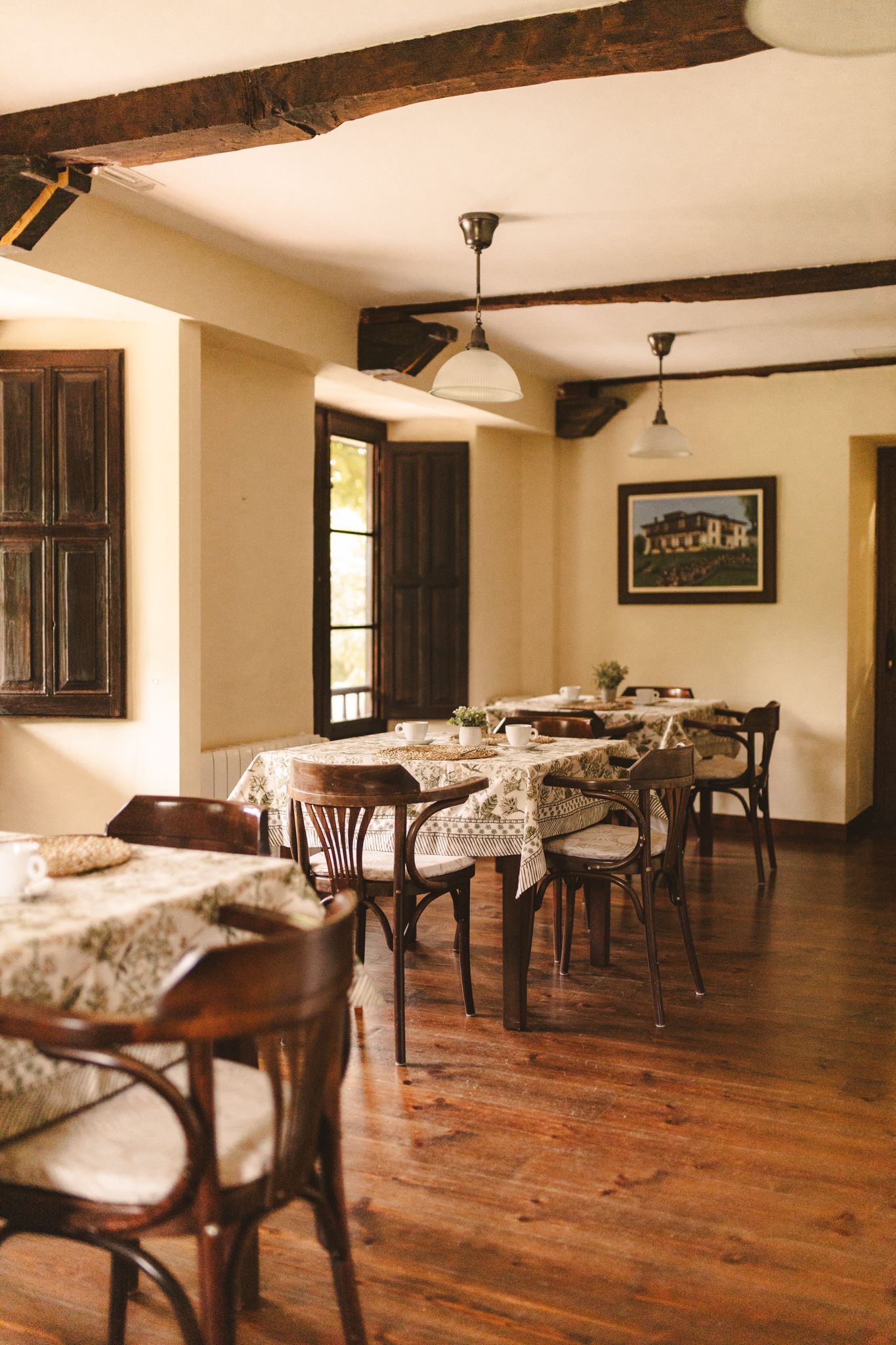 A restaurant with tables and chairs and a picture on the wall