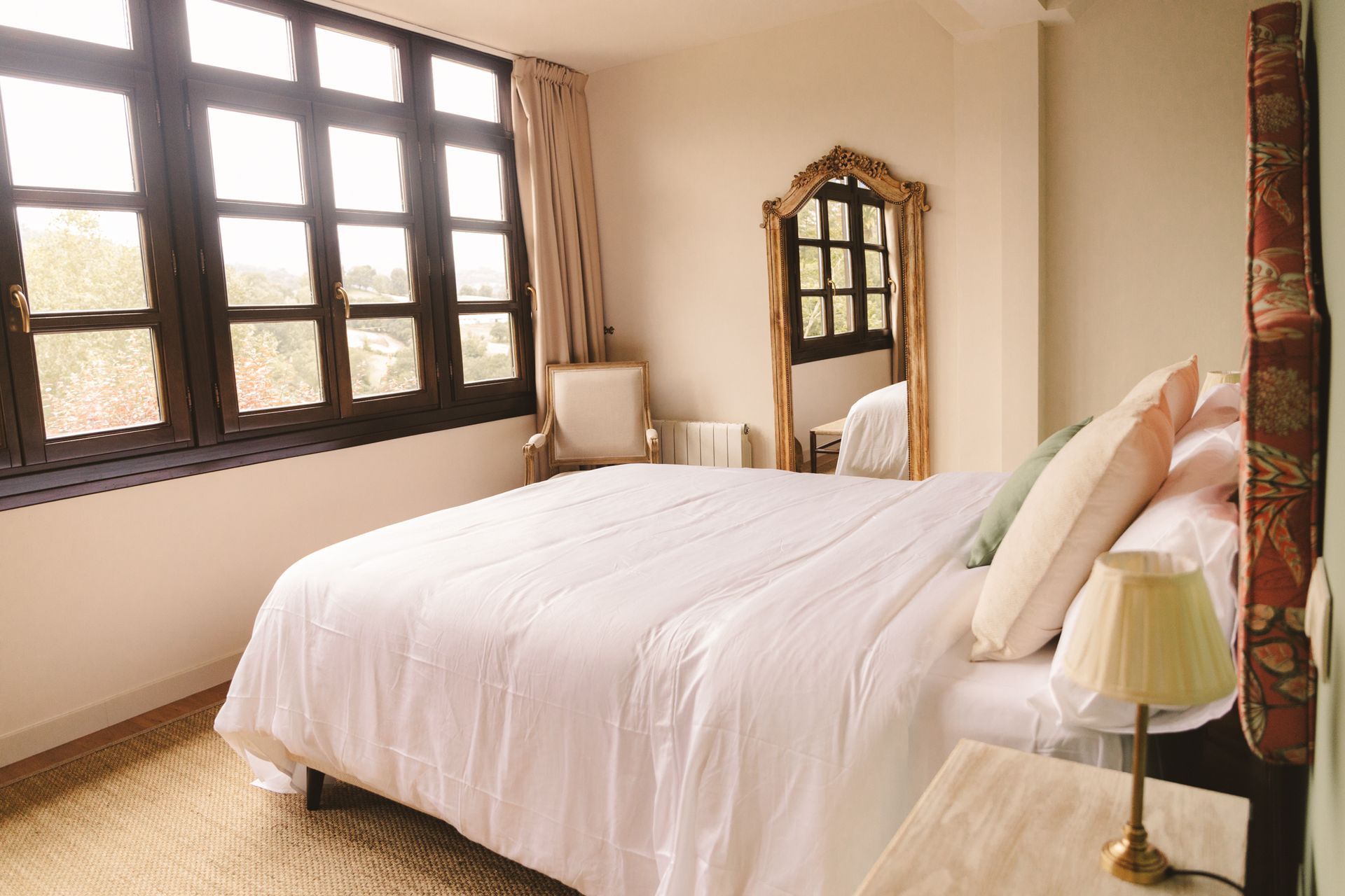 A bedroom with a large bed and a mirror