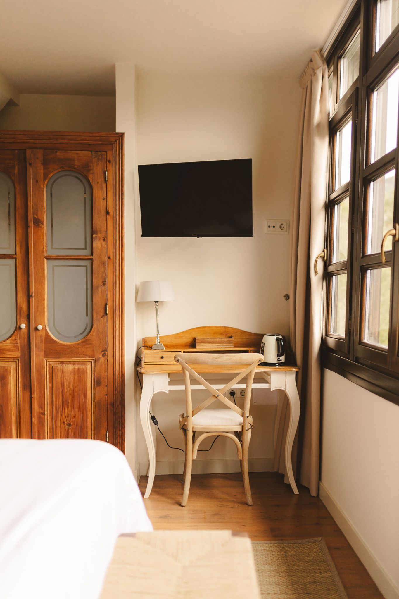 A bedroom with a desk , chair and television.