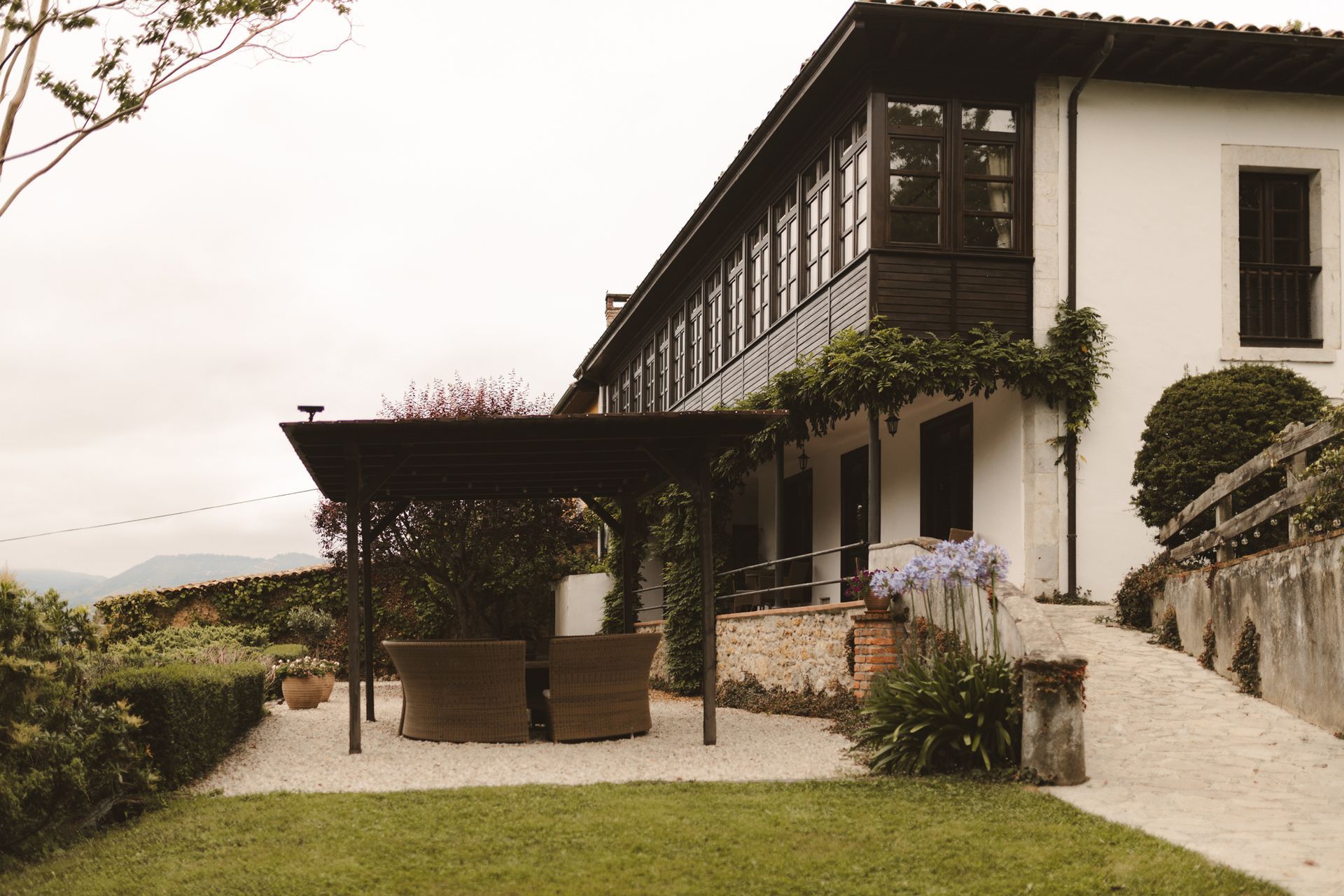 A large white house with a pergola in front of it