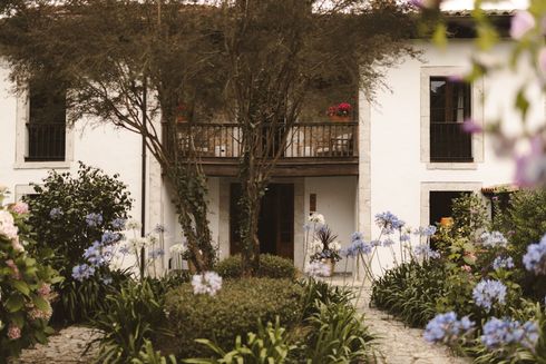 A white house with flowers in front of it