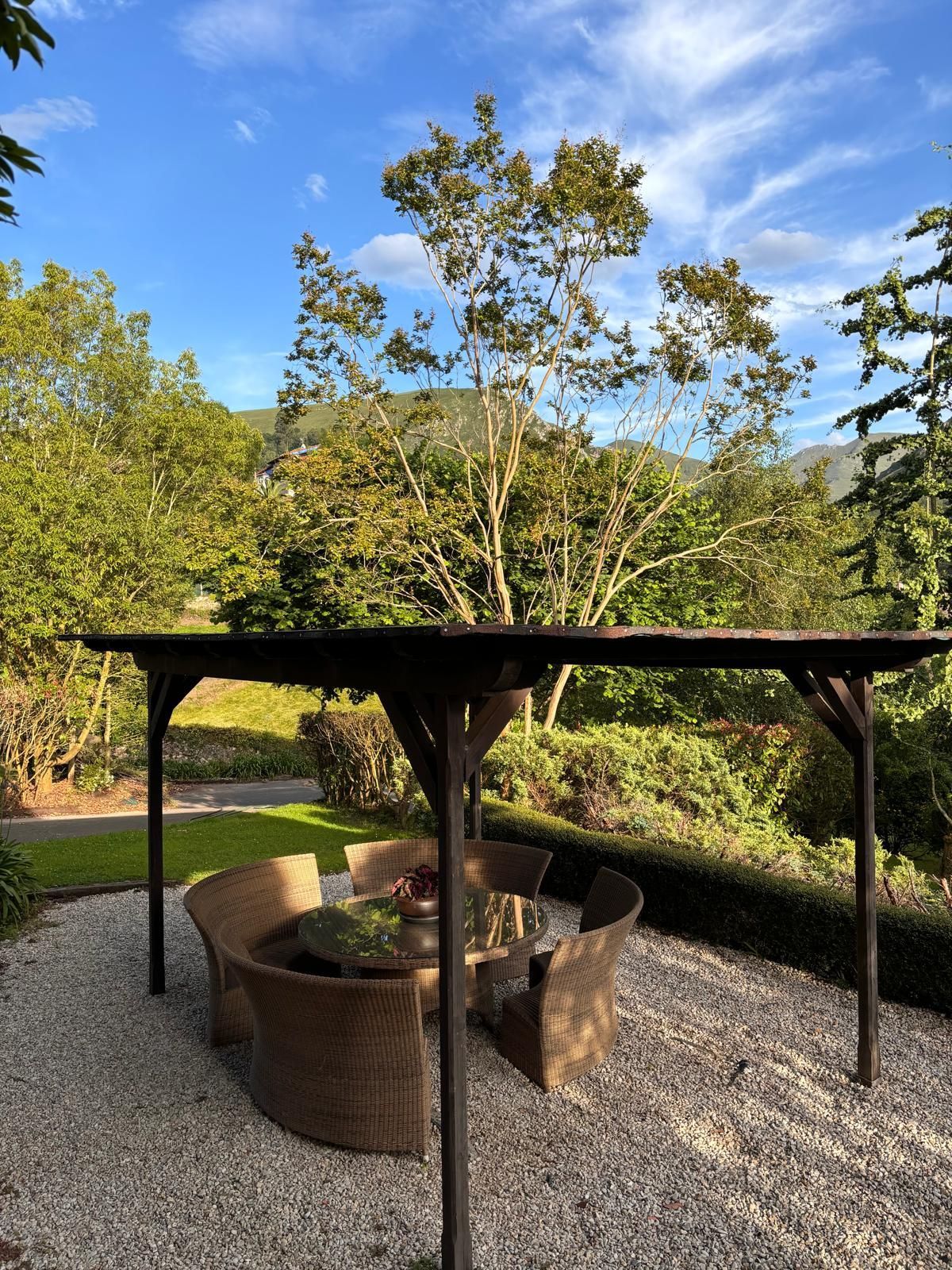 A patio with a table and chairs under a pergola.