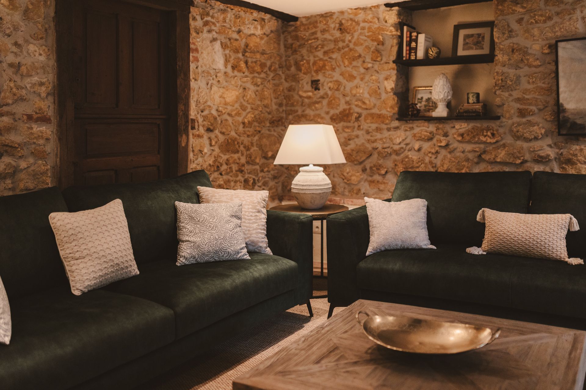 A living room with two couches , a coffee table , and a lamp.