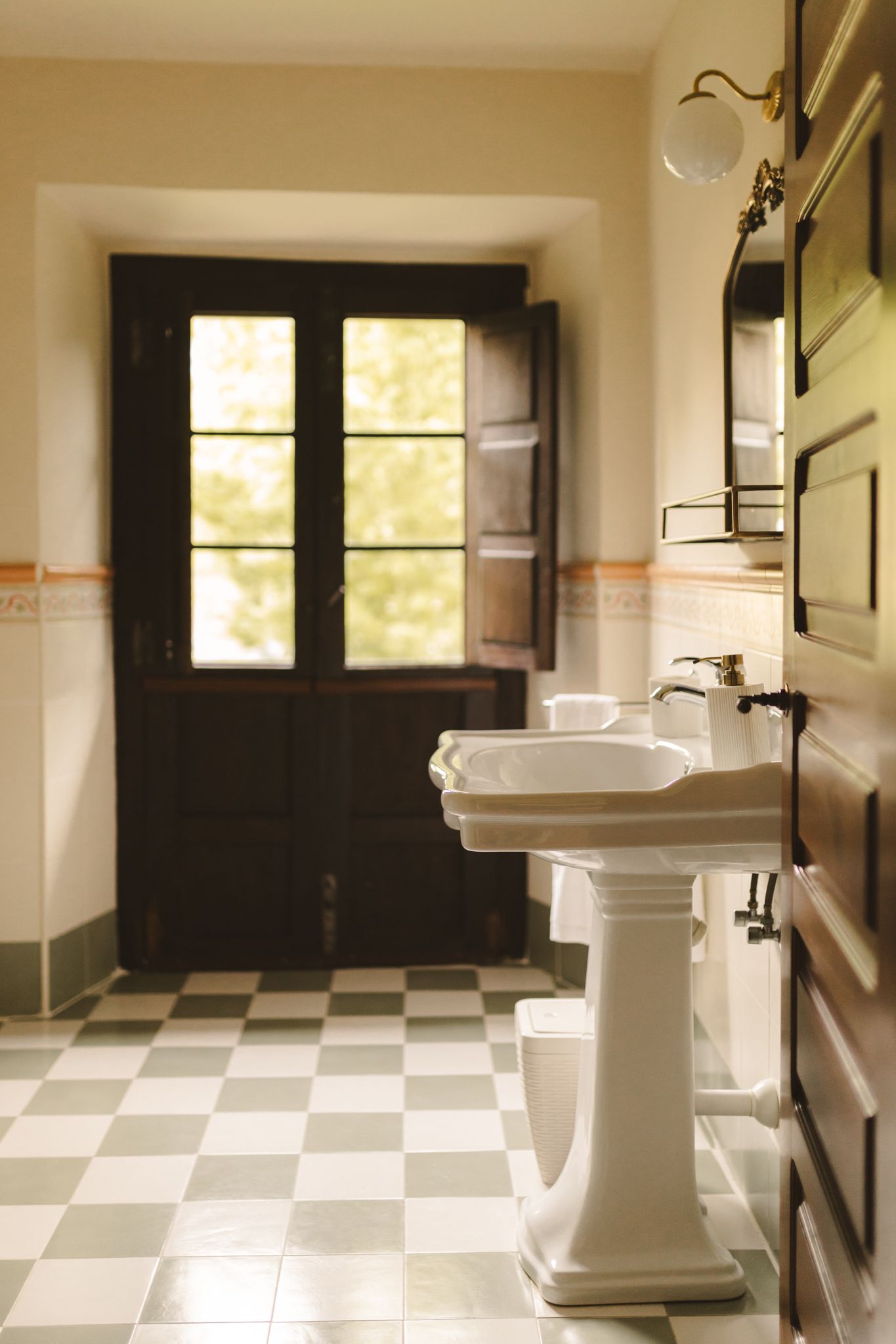 A bathroom with two sinks and a checkered floor