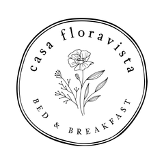 A black and white logo for a bed and breakfast with a flower in the center.