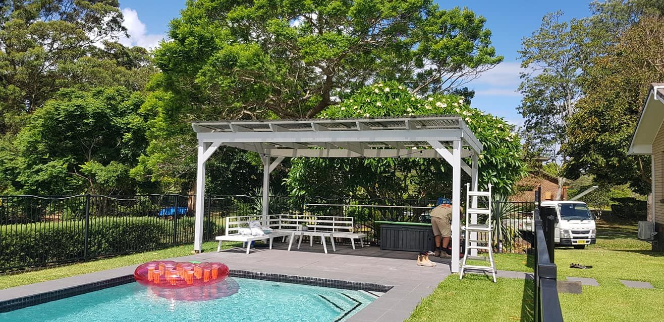 White Pergola is Sitting at The End Of The Pool — Red Dog Landscaping in Banora Point, NSW