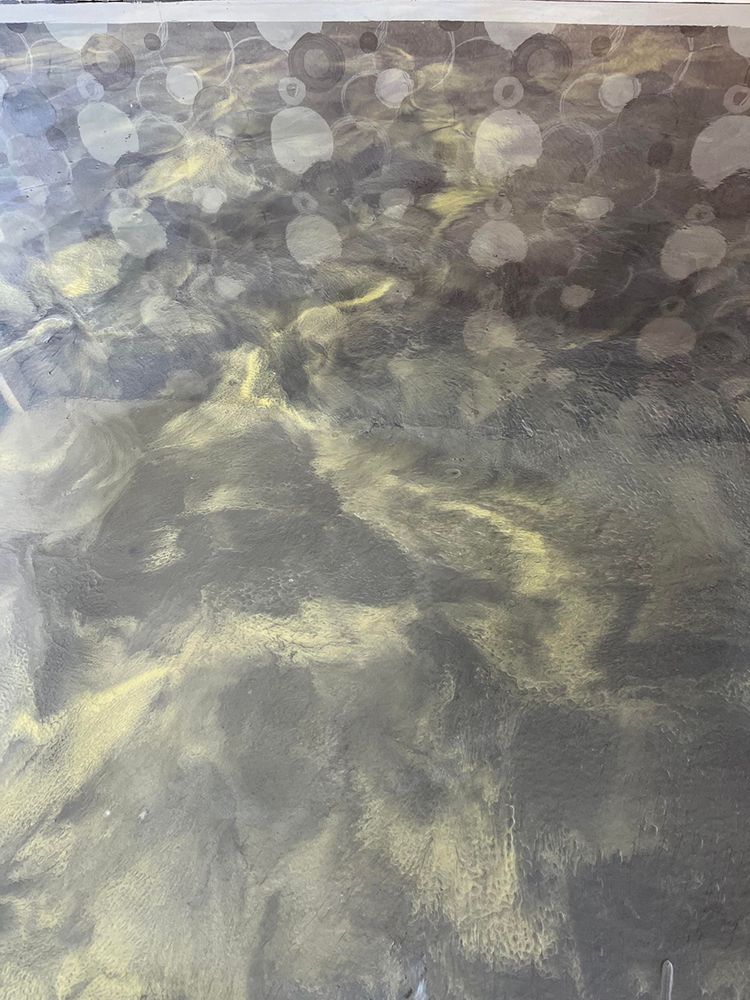 A close up of a black and gold painting on a wall