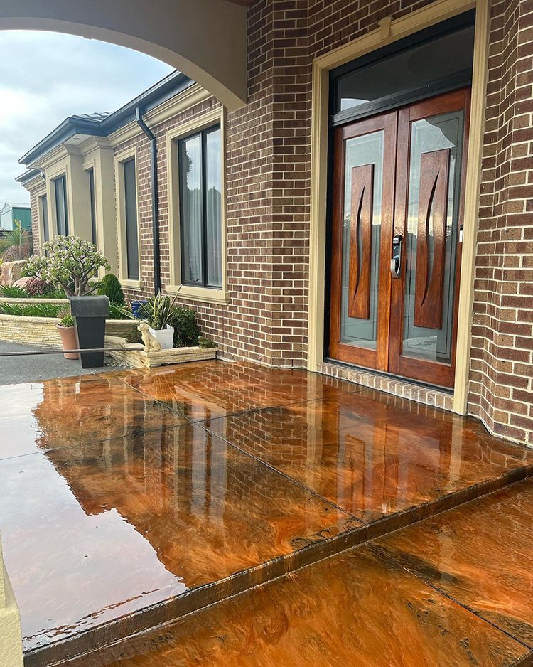 A brick building with a wooden door and a concrete walkway in front of it