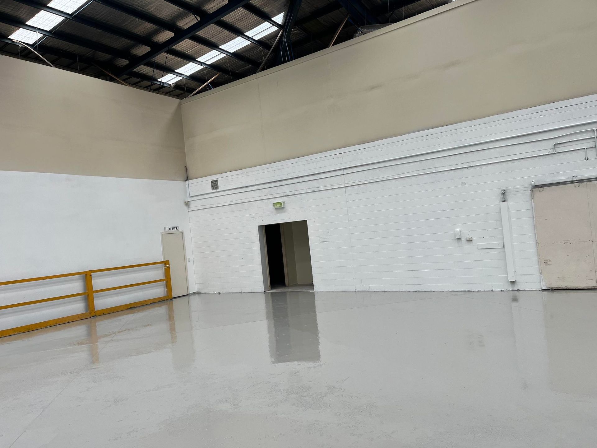 A large empty room with a gray floor and white walls