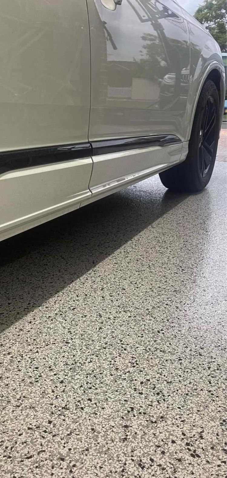 A car is parked in a garage with a concrete floor
