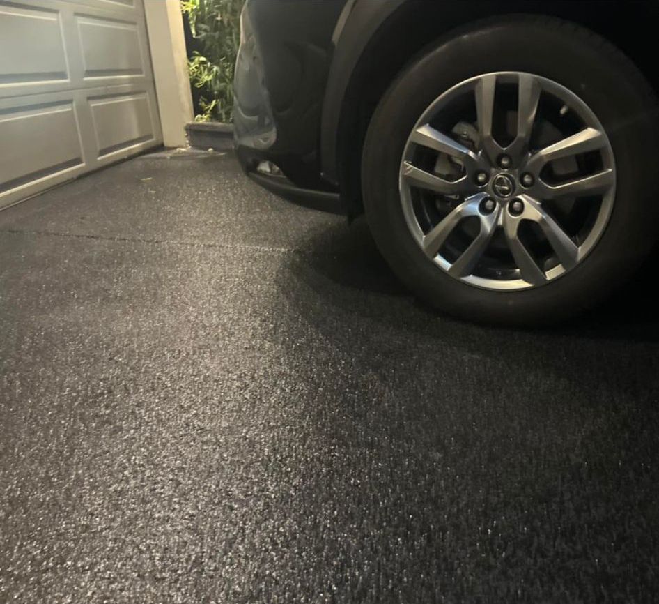 A car is parked in a garage next to a garage door
